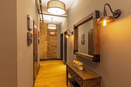 - un couloir avec un miroir et une table fleurie dans l'établissement Hip Urban Loft-Small Town Charm-124 LOFTS #2, à West Dundee