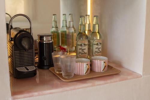 a shelf with a bunch of wine bottles and cups at Casa Gitano in Tulum
