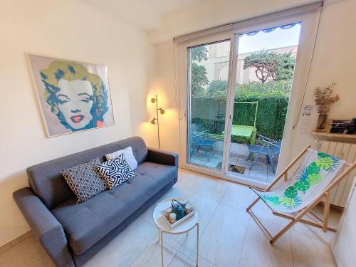 un salon avec un canapé bleu et une fenêtre dans l'établissement Nestor&Jeeves - MARYLIN - Central - Very close sea, à Nice