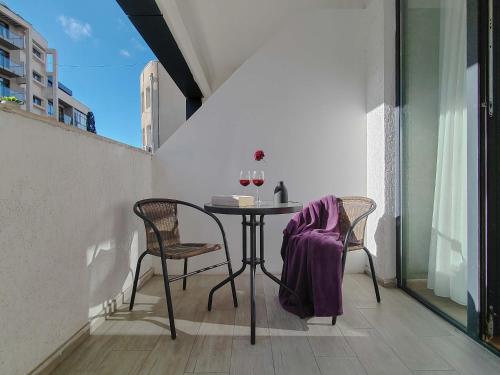 una mesa con dos sillas y una manta morada. en Round Garden Hotel, en Tiflis