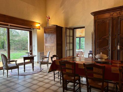 une salle à manger avec une table et des chaises dans l'établissement Maison Paisible avec Lac Privé, à Secondigny