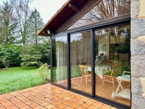 une véranda avec des portes coulissantes en verre sur une terrasse dans l'établissement Maison Paisible avec Lac Privé, à Secondigny