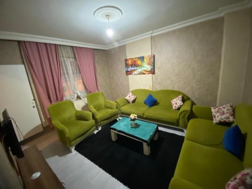 sala de estar con sofás verdes y mesa en GÜL APART SUİT, en Estambul