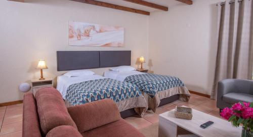 a hotel room with a bed and a couch at Bio Quinta do Pantano, Agro Turismo in Santo António da Serra