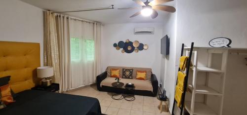 a living room with a bed and a ceiling fan at Le Madina in Pamandzi