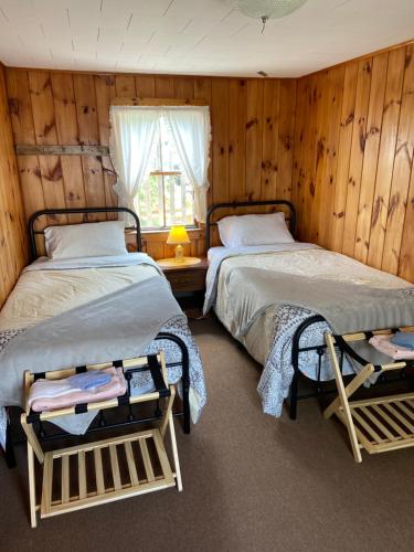 2 camas en una habitación con paredes de madera en Spinneys Guesthouse & Beach Cottages, en Phippsburg