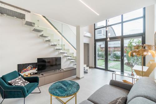 a living room with a staircase and a tv at Urban Garden by Blue Velvet Livings in Milan