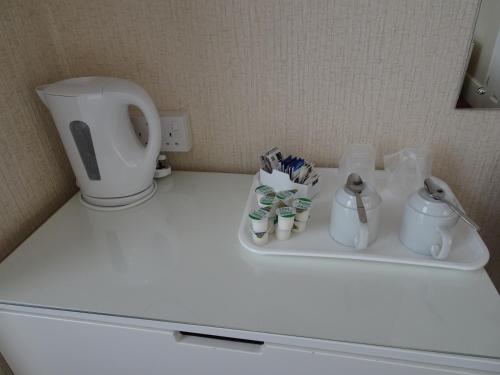 Una encimera blanca con inodoro y tazas. en Haddon Hall Hotel, en Eastbourne
