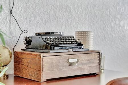 an old typewriter sitting on top of a wooden box at The Hemingway subtropical luxury on the Tampa Bay in Tampa