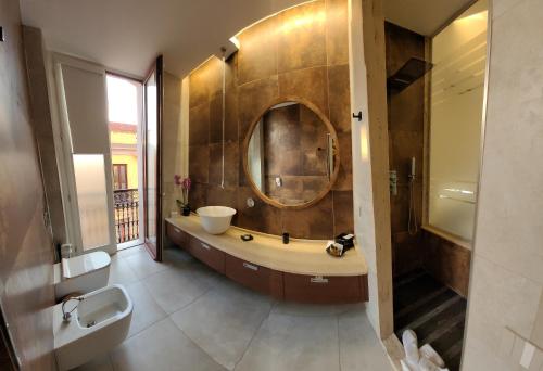 a bathroom with a large sink and a mirror at Palazzo Ferrucci Luxury Suites in Cagliari