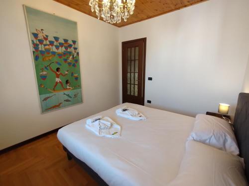 a bedroom with a bed with two towels on it at La Casa Veneta - Hostel in Muggia