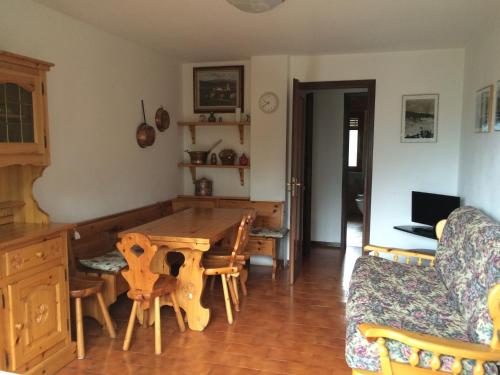 sala de estar con mesa de madera y sofá en Maison du Camillo, en Sauze dʼOulx