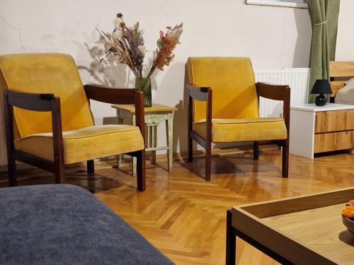un soggiorno con tavolo e sedie gialle di Nomad Apartment Braşov a Braşov