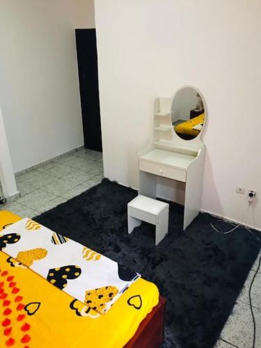 a room with a mirror and a bed and a desk at HAVRE DE CHARME A YAOUNDE in Yaoundé