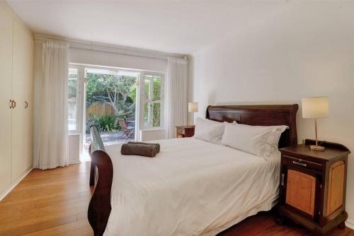 a bedroom with a large white bed and a window at Sunbird Cottage - Wilderness in Wilderness