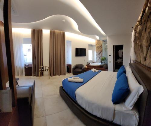 a bedroom with a large bed with blue pillows at Palazzo Ferrucci Luxury Suites in Cagliari
