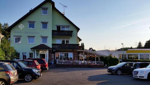 a large building with cars parked in a parking lot at Hotel Restaurant Anna in Ramstein-Miesenbach