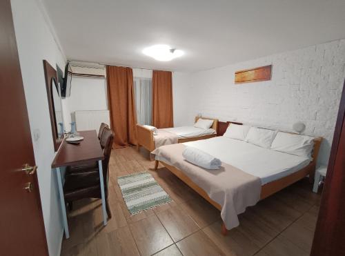 een slaapkamer met een bed, een tafel en een bureau bij Pensiunea Johanna in Arad