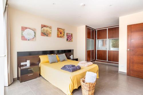 ein Schlafzimmer mit einem großen Bett und einer gelben Decke in der Unterkunft My Casa Ferrera in Cala Ferrera