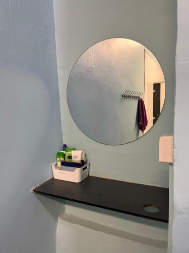 a bathroom with a mirror and a shelf with a sink at Bath Backpackers in Bath