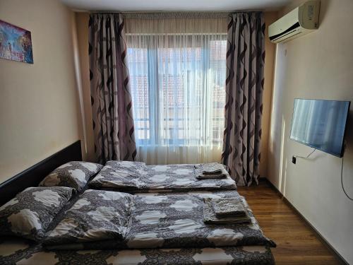 a bedroom with two beds in front of a window at City Sandanski in Sandanski