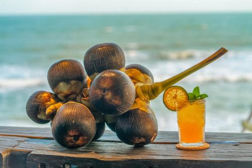 a pile of fruit on a table with a drink at Long Hải Channel Beach Resort in Long Hai
