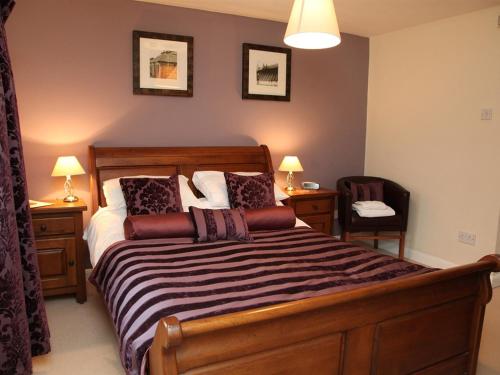 a bedroom with a bed and two tables and a chair at The Collyweston Slater in Collyweston