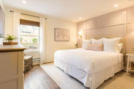Un dormitorio con una gran cama blanca y una ventana en Downtown Luxury Farmhouse Apartment #1, en West Dundee