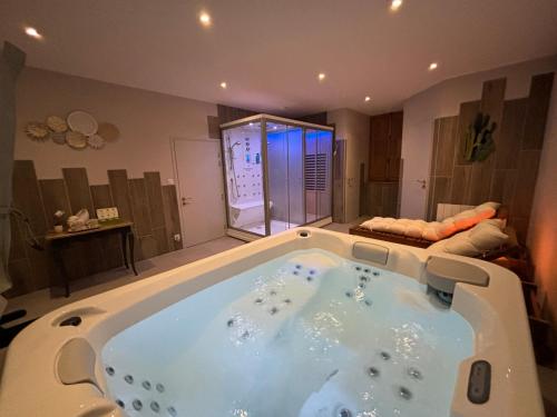 a large bath tub in a room with a bed at Mesnil Montrivaut in Viévigne