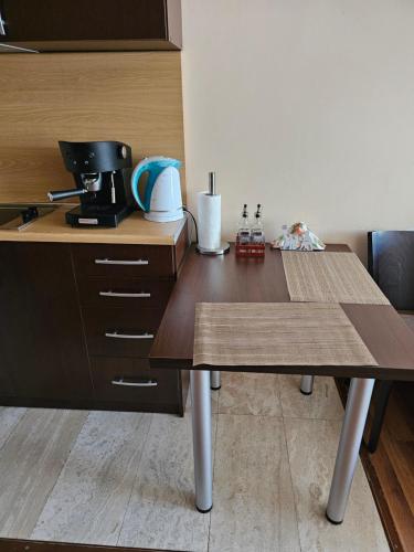 a kitchen with a wooden table with a coffee maker at City Sandanski in Sandanski