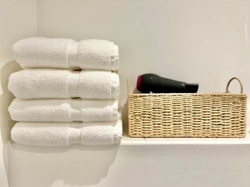 a stack of towels and a basket on a shelf at Bright, stylish flat in Hatfield sleeps 4 in Hatfield