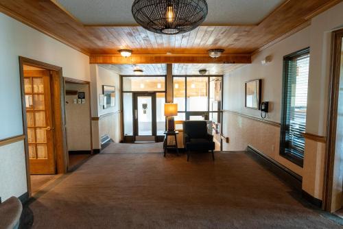 an empty hallway with a chair and a lamp at Auberge le Parasol in Saguenay