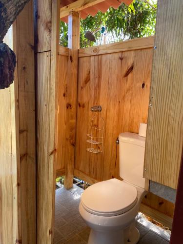 a bathroom with a toilet in a wooden wall at A Piece of Paradise in San Carlos