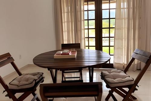 uma mesa de jantar com cadeiras e um livro sobre ela em Morada Das Cerejeiras - Espaçosa e Ideal para Pets em Rio Forcação