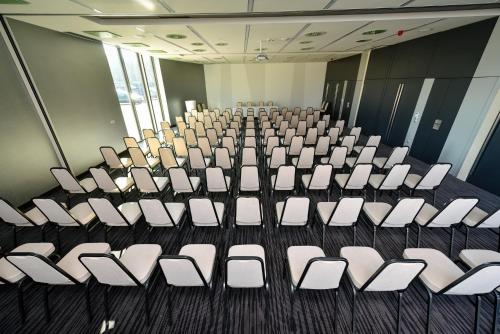 a room with rows of white chairs in it at Best Western Plus Lakeside Hotel in Székesfehérvár