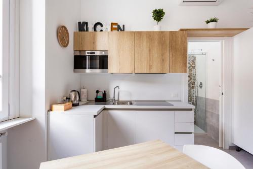 a kitchen with white cabinets and a sink at Urban Nest Apartments in Milan
