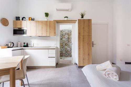 a small kitchen with white cabinets and a table at Urban Nest Apartments in Milan
