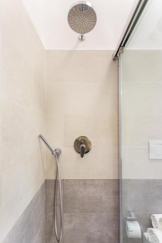 a shower with a glass door in a bathroom at Urban Nest Apartments in Milan
