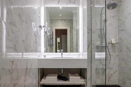 a bathroom with a sink and a shower with a mirror at Modern Art Hotel in Lviv