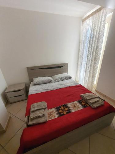 sypialnia z łóżkiem z czerwonym kocem i oknem w obiekcie Appartamento Vacanza Mare Gioiosa Marea Zappardino w mieście Gioiosa Marea