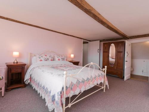 a bedroom with a white bed and two night stands at West House Farm in Leiston