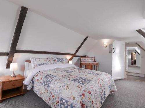 a bedroom with a large bed and a white wall at West House Farm in Leiston