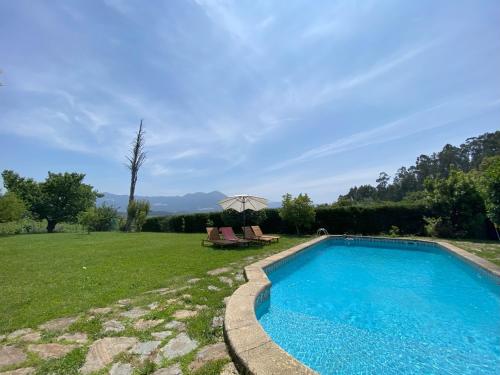 a swimming pool in a yard with a table and chairs at Turra Nature House in Celorico de Basto