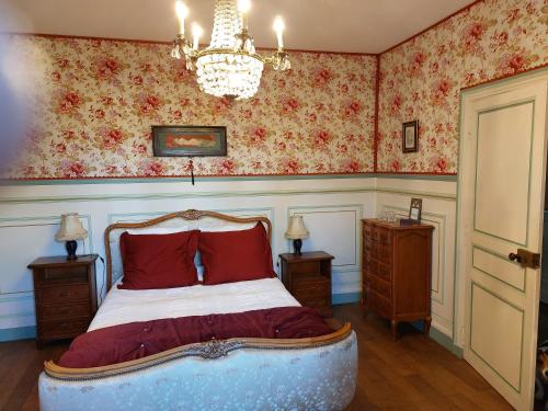 a bedroom with a bed and a chandelier at La Gueriniere l'anglaise in Châteauneuf-sur-Charente