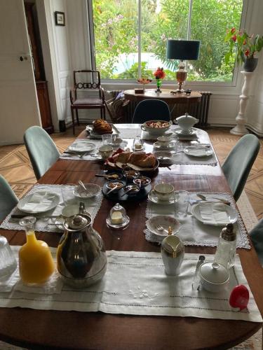 a wooden table with food and dishes on it at La Gueriniere l'anglaise in Châteauneuf-sur-Charente