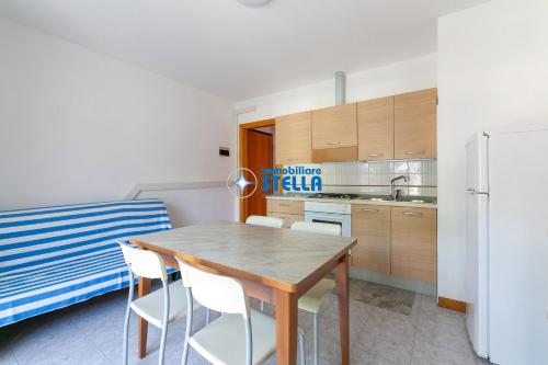 a kitchen with a table and chairs and a refrigerator at Residence Adriatica in Lido di Jesolo