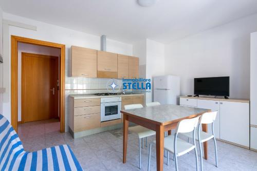 a kitchen with a table and a kitchen with a refrigerator at Residence Adriatica in Lido di Jesolo