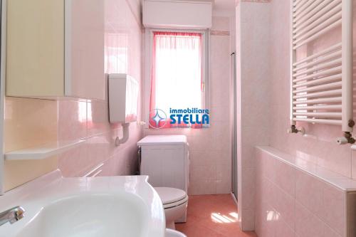 a white bathroom with a toilet and a sink at Residence Adriatica in Lido di Jesolo