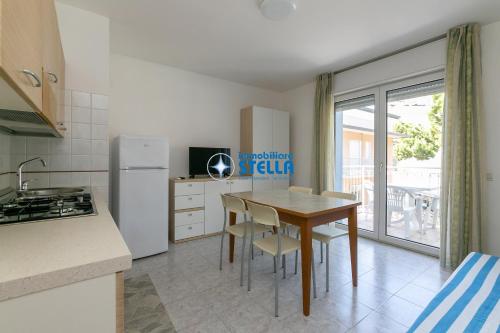 a kitchen with a table and a refrigerator at Residence Adriatica in Lido di Jesolo
