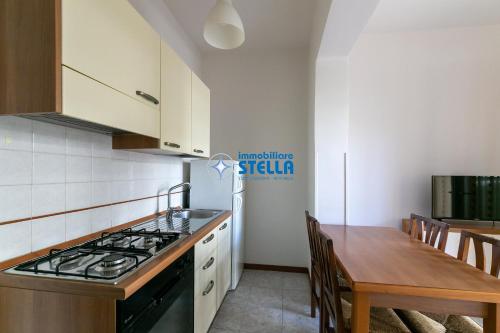 a kitchen with a stove and a wooden table at Residence Adriatica in Lido di Jesolo